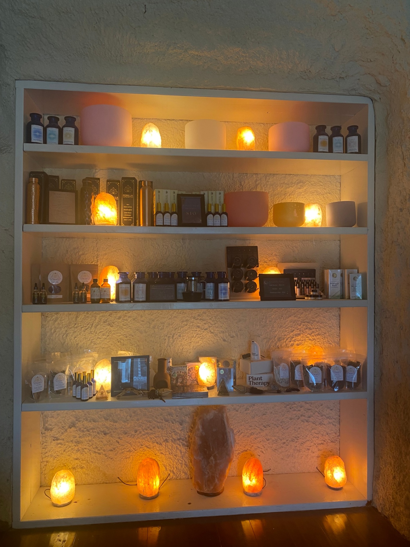 Apothecary shelves lit with salt lamps and herbs